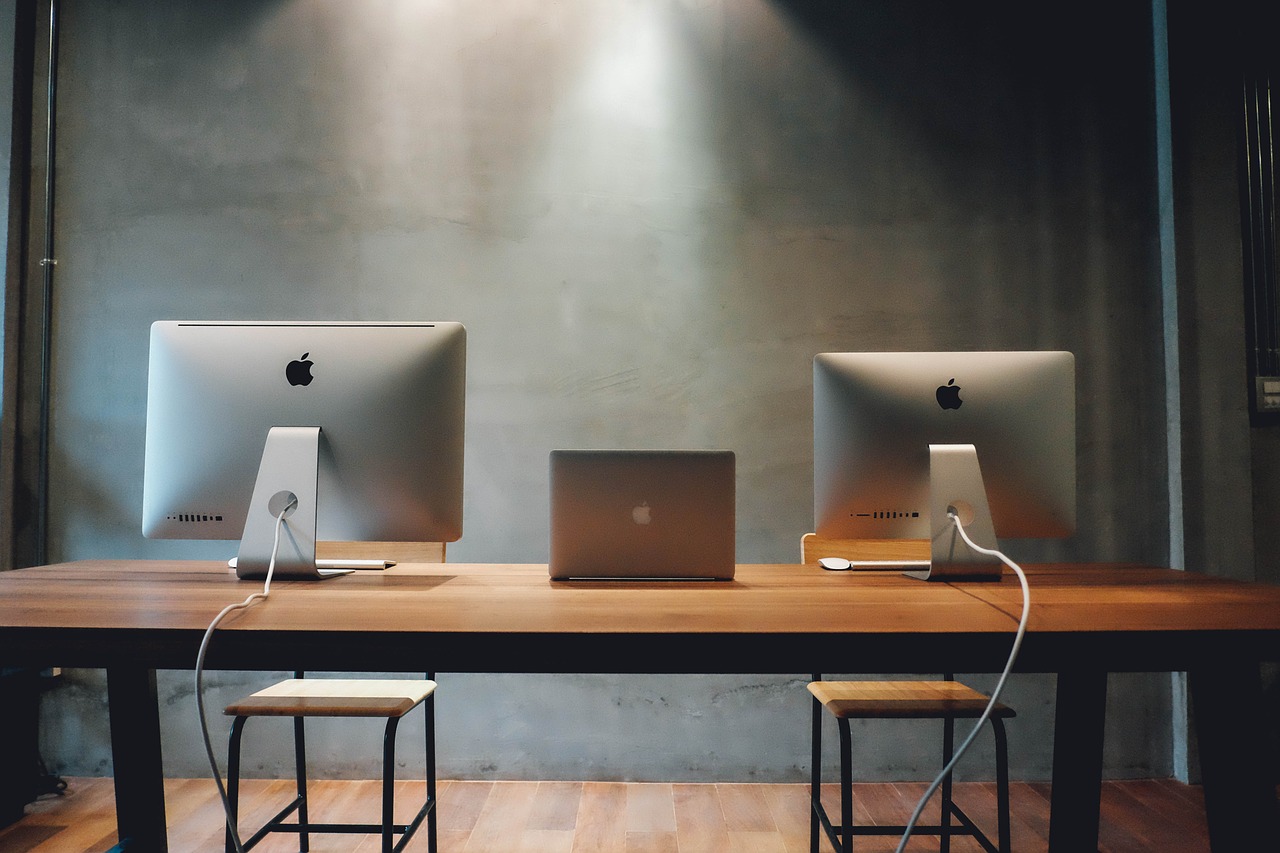 espaço de trabalho com três computadores.